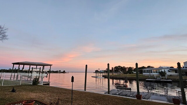 dock area featuring a water view and a lawn