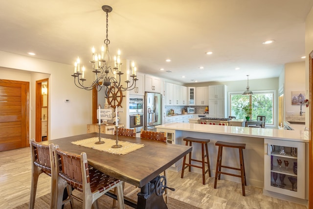 dining room with light hardwood / wood-style flooring, an inviting chandelier, and beverage cooler