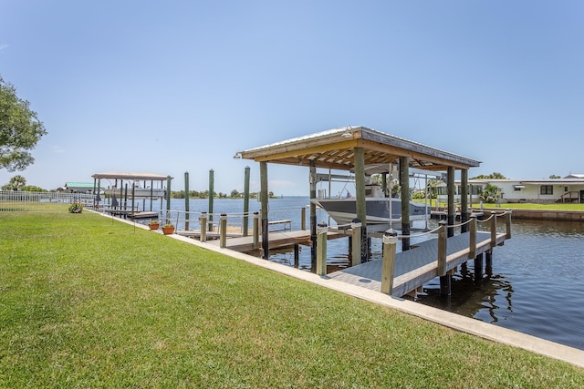 view of dock with a yard and a water view