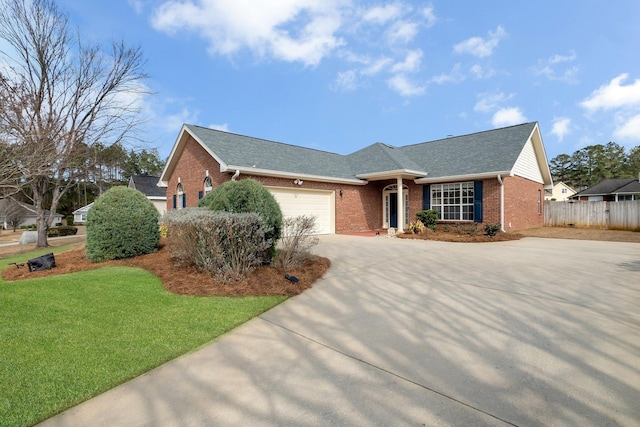 ranch-style home featuring fence, a front lawn, driveway, a garage, and brick siding