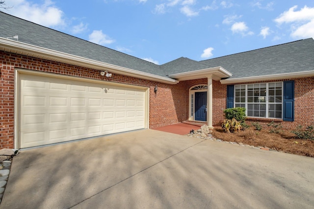 single story home with roof with shingles, driveway, an attached garage, and brick siding