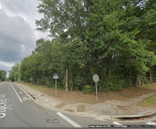 view of road with curbs, traffic signs, and sidewalks