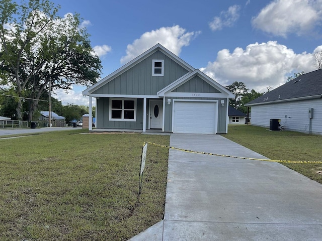 1422 Mccaskill Ave, Tallahassee, FL 32310 - view of front of home featuring board and batten siding, concrete driveway, cooling unit, a front yard, and an attached garage