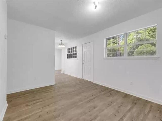 2705 Lake Henrietta St, Tallahassee, FL 32310 - empty room with baseboards, a chandelier, and wood finished floors