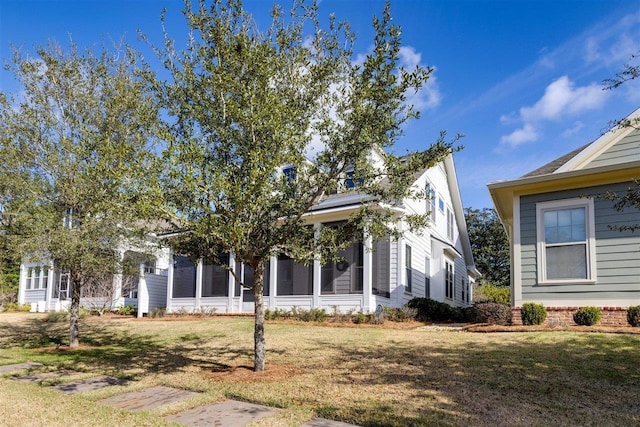 view of front of property featuring a front yard and a sunroom