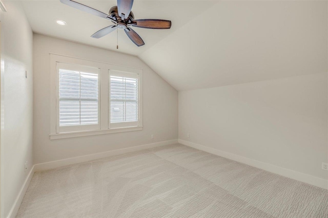 additional living space with light carpet, baseboards, vaulted ceiling, and a ceiling fan