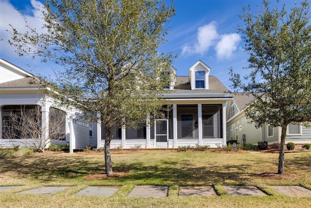 view of front of property with an attached garage, a front yard, and a sunroom