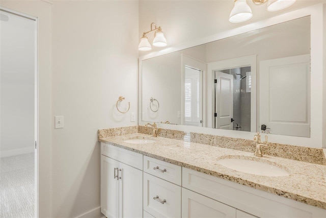 full bathroom featuring double vanity, baseboards, and a sink