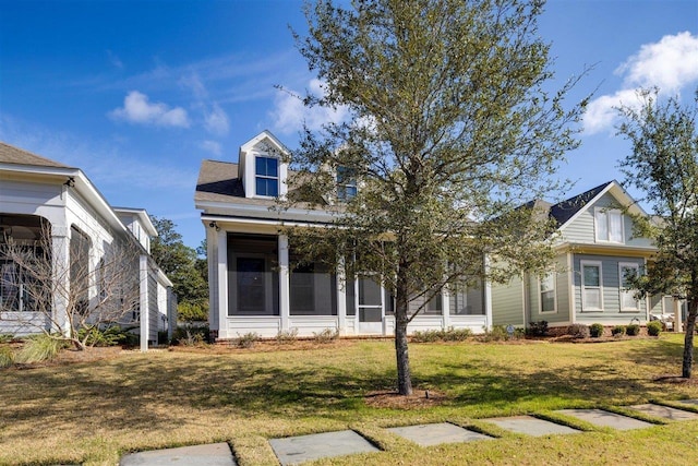 view of front of house featuring a sunroom and a front lawn