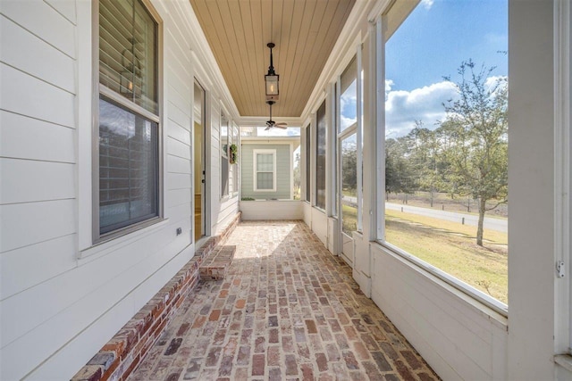 unfurnished sunroom with wooden ceiling and ceiling fan