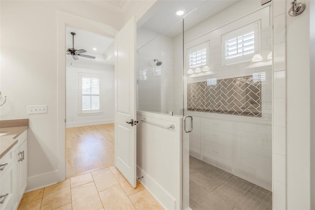 full bath with a healthy amount of sunlight, a shower stall, tile patterned flooring, and vanity