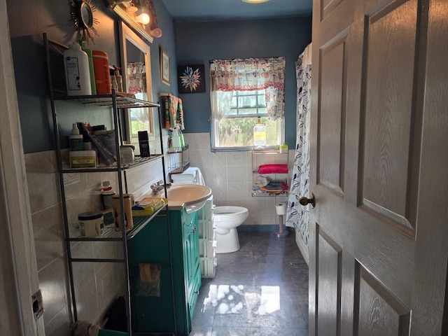 full bathroom with vanity, wainscoting, toilet, and tile walls