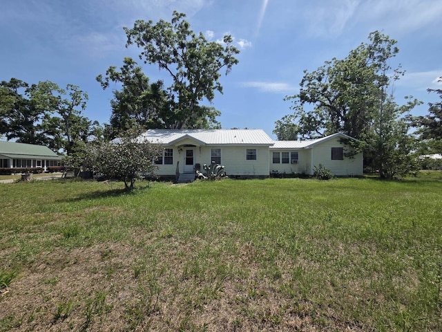back of house with a lawn and metal roof