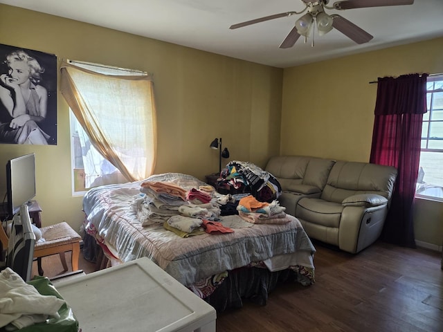 bedroom featuring ceiling fan, multiple windows, and wood finished floors