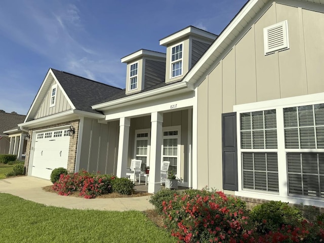 view of property exterior featuring a porch, board and batten siding, a garage, concrete driveway, and a shingled roof