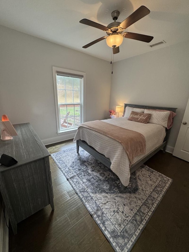 bedroom featuring baseboards, a ceiling fan, dark wood-type flooring, and visible vents