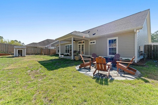 rear view of property featuring ceiling fan, a fenced backyard, french doors, a patio area, and a lawn