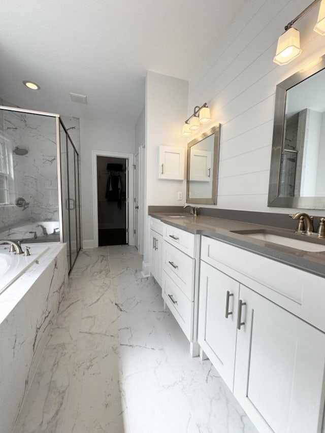 bathroom with a garden tub, a sink, a marble finish shower, and marble finish floor