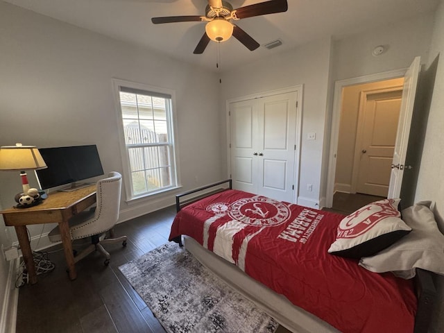 bedroom featuring visible vents, a closet, baseboards, a ceiling fan, and dark wood finished floors