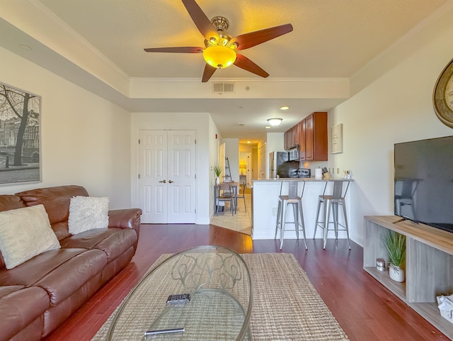 living room with crown molding, ceiling fan, and light wood-type flooring