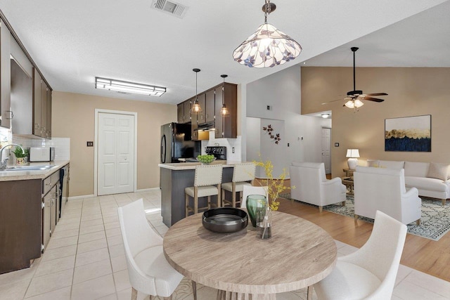 tiled dining space with sink and ceiling fan