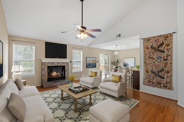 living room with hardwood / wood-style flooring, plenty of natural light, a fireplace, and vaulted ceiling