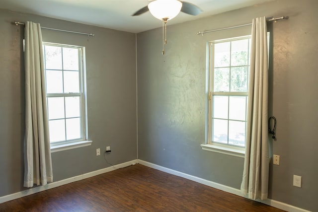 unfurnished room with dark wood-type flooring, ceiling fan, and a healthy amount of sunlight