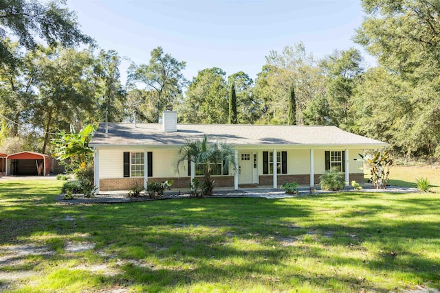 ranch-style home featuring covered porch and a front lawn