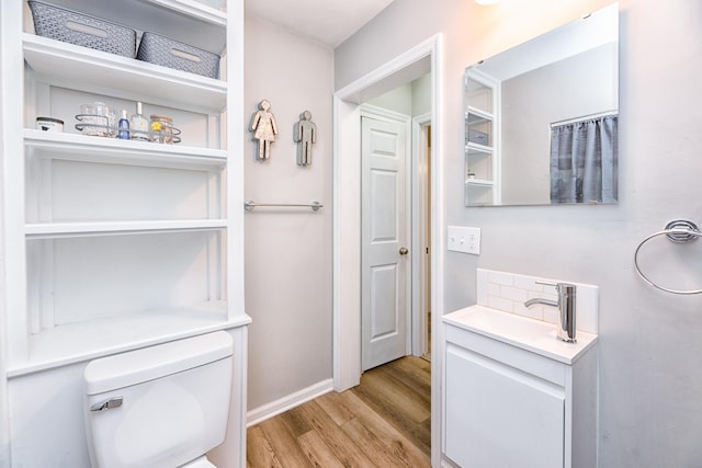 bathroom featuring toilet, vanity, and hardwood / wood-style flooring