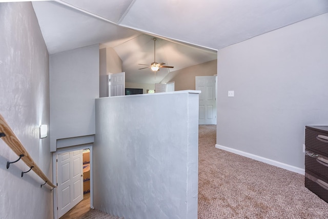 staircase with ceiling fan, carpet floors, and vaulted ceiling