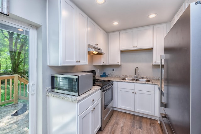 kitchen with sink, wood-type flooring, white cabinetry, and appliances with stainless steel finishes