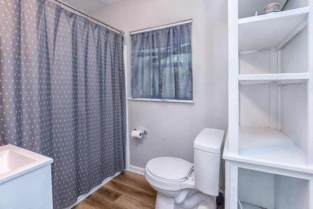 bathroom with toilet, a shower with shower curtain, and hardwood / wood-style floors