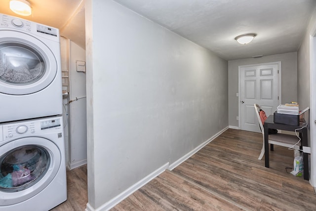 clothes washing area with wood-type flooring and stacked washer / dryer