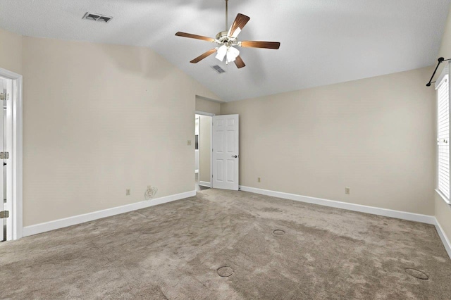 carpeted spare room featuring vaulted ceiling and ceiling fan