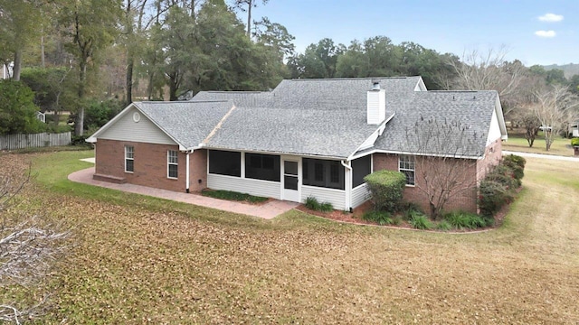 exterior space featuring a sunroom, a patio area, and a front lawn