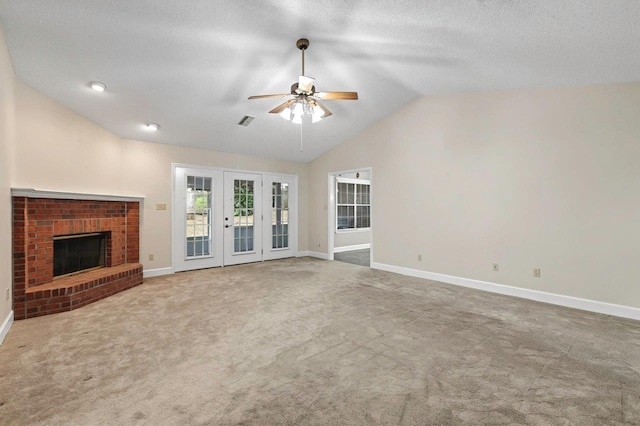 unfurnished living room featuring ceiling fan, carpet, a fireplace, a textured ceiling, and vaulted ceiling