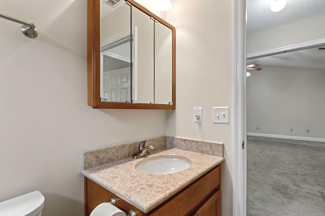 bathroom featuring vanity, a textured ceiling, and toilet