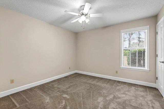 empty room featuring ceiling fan, light carpet, and a textured ceiling