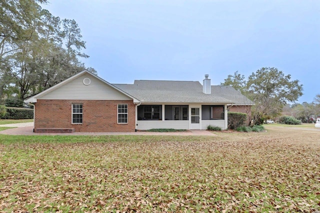 back of house featuring a yard and a sunroom