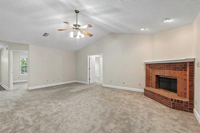 unfurnished living room featuring ceiling fan, lofted ceiling, a fireplace, and light carpet