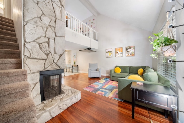 living area featuring stairway, high vaulted ceiling, wood finished floors, beamed ceiling, and baseboards
