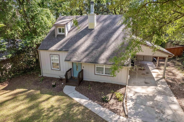 view of front facade with a chimney, a front lawn, driveway, fence, and roof with shingles