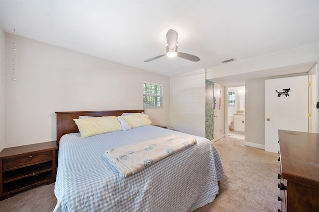 bedroom with connected bathroom, ceiling fan, light carpet, and visible vents