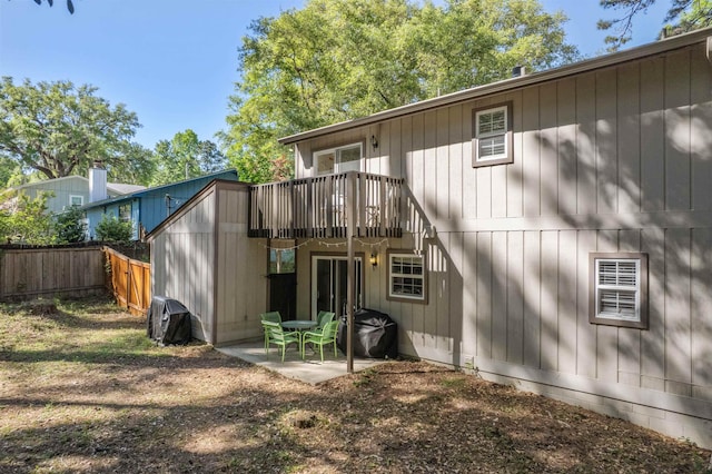 rear view of property featuring a patio area and fence