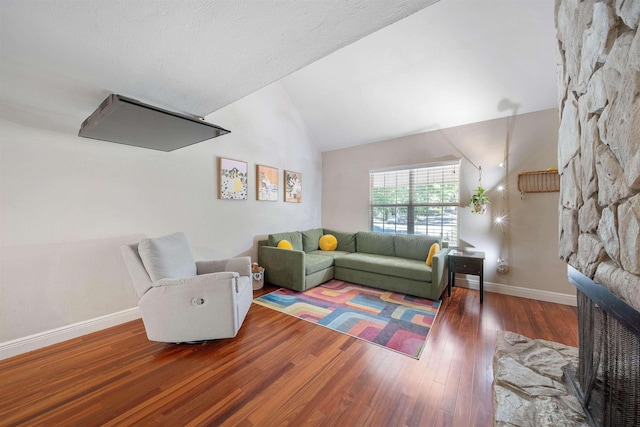 living room with a fireplace, hardwood / wood-style floors, lofted ceiling, and baseboards