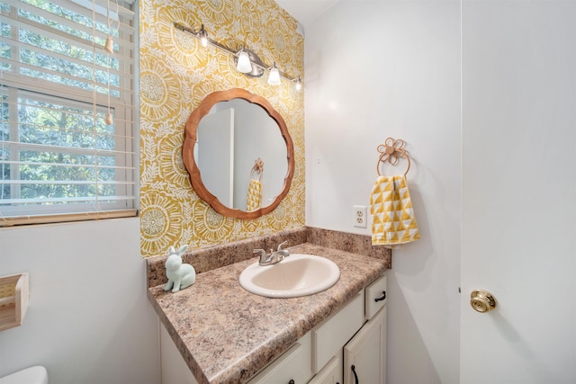 bathroom featuring vanity and wallpapered walls