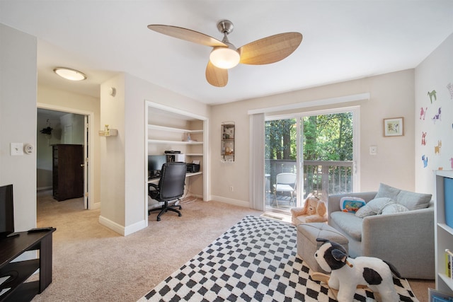 interior space with a ceiling fan, baseboards, built in shelves, and light colored carpet