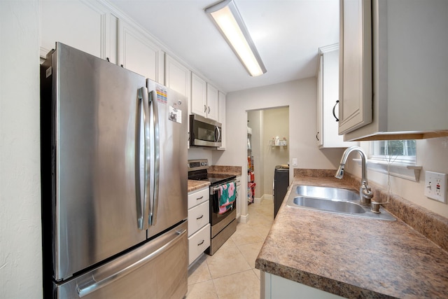kitchen with white cabinets, light tile patterned floors, a sink, and appliances with stainless steel finishes