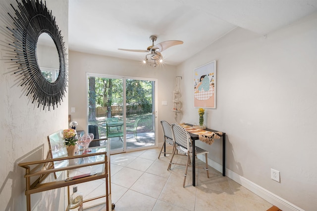 dining area featuring baseboards, ceiling fan, and light tile patterned flooring
