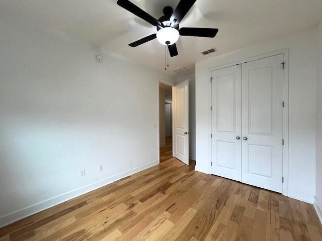 unfurnished bedroom featuring a closet, light wood-type flooring, and ceiling fan